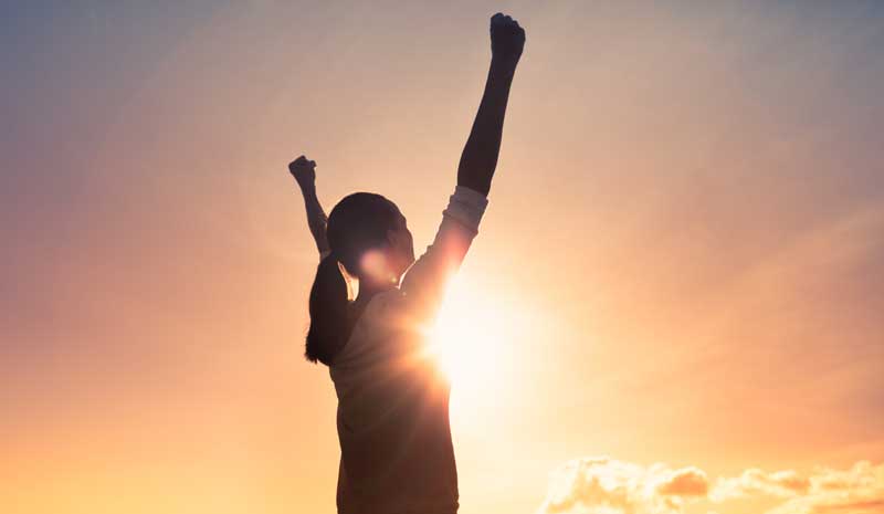 Strong, motivated woman with fist up to the sky. People feeling